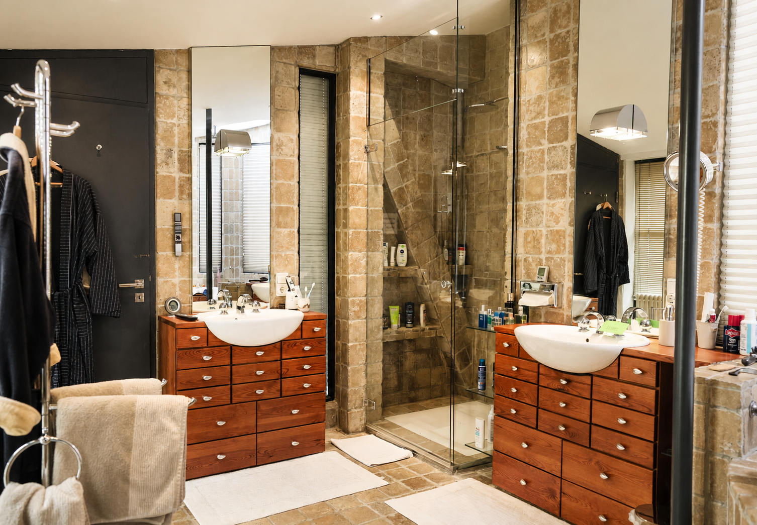 Natursteinbad mit runder Badewanne im Hauptschlafzimmer des Lofts